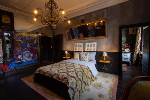 sypialnia z łóżkiem i żyrandolem w obiekcie Château de Clemency w mieście Clemency