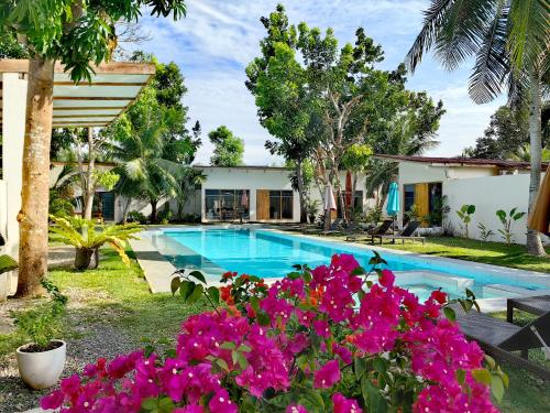 a villa with a swimming pool and flowers at Island World Panglao in Panglao Island