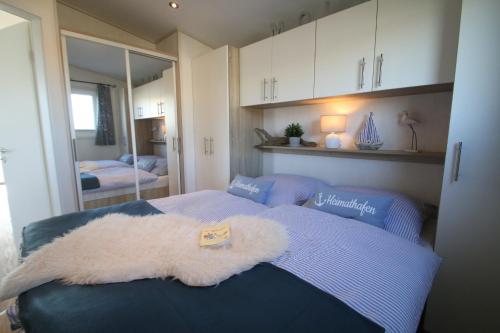 a bedroom with a bed with a white blanket on it at Offizier 12 in Neustadt in Holstein