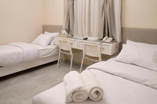 a bedroom with two beds and a desk with two chairs at Dream House in 6th Of October