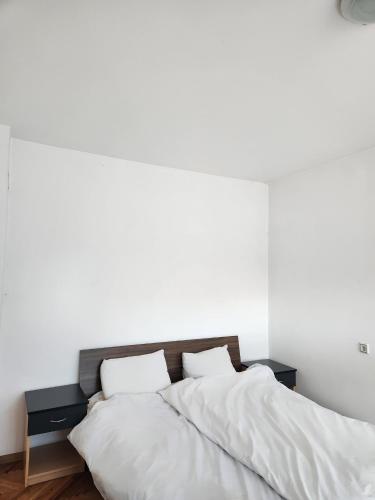 a white bedroom with two beds with white sheets at House ViS in Dimitrovgrad