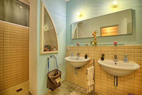 łazienka z 2 umywalkami i lustrem w obiekcie Casa Riva by PosarelliVillas w mieście San Vincenzo