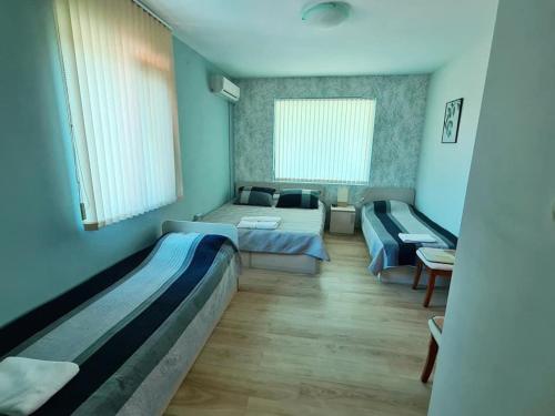 een slaapkamer met 2 bedden en een bank bij House Varna-3 in Krapets