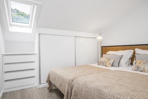 - une chambre blanche avec un grand lit et une fenêtre dans l'établissement Upland Home II By Madeira Sun Travel, à Ponta do Sol