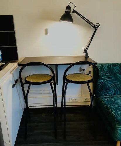 un bureau avec deux chaises et une lampe à côté d'un canapé dans l'établissement L'Arquebuse - Cité de la Gastronomie, à Dijon