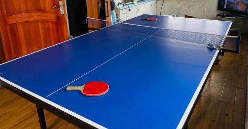 a ping pong table with a ping paddle on it at Travelers Guest House in Ölgiy