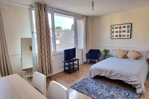 a bedroom with a bed and a large window at Large Duplex in Bermondsey in London