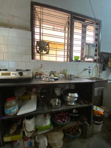 a kitchen with a sink and a counter with food at Lake Land Guest House in Kolkata