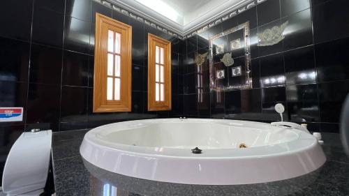 ニハルにあるCasa Duende en Villa de Nijar con piscinaの黒いバスルーム(白い大型バスタブ付)