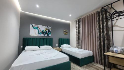 sypialnia z 2 łóżkami i oknem w obiekcie Guest House Tian w Durrës