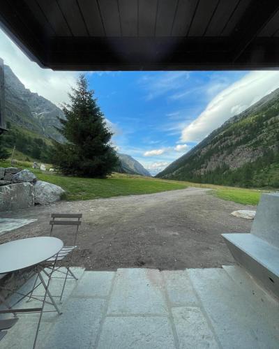 a table and chairs in a parking lot with mountains at La Rêverie de Thumel - Suite in Rhêmes-Notre-Dame