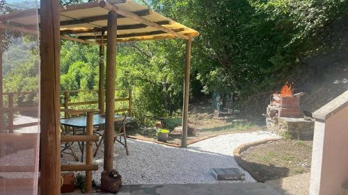 a wooden pergola with a table and a grill at Lo scoiattolo bianco in Massa