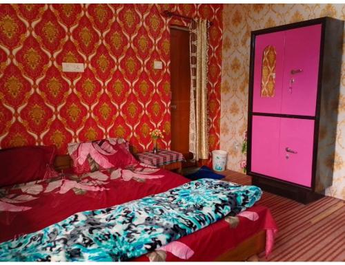 una camera con letto e parete rosa di Safaya Paying Guest House and Home Stay, Patnitop a Patnitop
