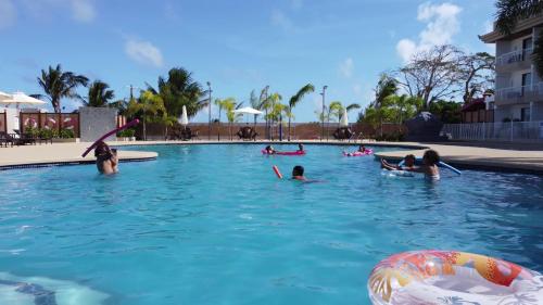 塞班的住宿－Paradiso Resort & Spa，一群人在度假村的游泳池里