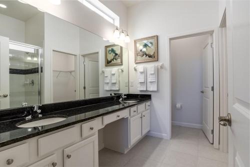 a bathroom with two sinks and a large mirror at Private Pool Homes in Kissimmee