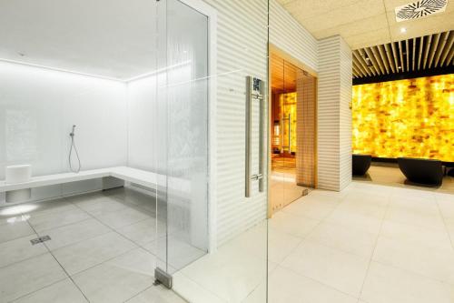 a glass shower in a bathroom with white tiles at Seaside Luxury Apartament in Kołobrzeg