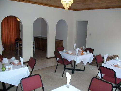 OlifantsfonteinにあるPalesa Guesthouseのダイニングルーム(白いテーブル、赤い椅子付)