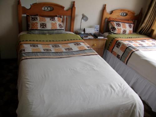 OlifantsfonteinにあるPalesa Guesthouseのベッド2台が隣同士に設置された部屋です。