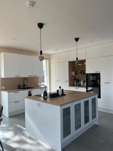 a kitchen with white cabinets and a white counter top at Villa Golden House in Rovaniemi