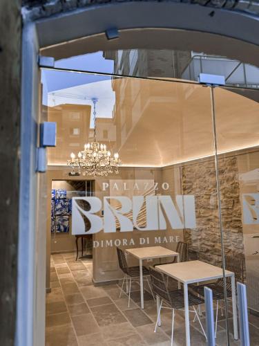 a store window with a table and chairs and a sign at B&B Palazzo Bruni - Dimora di Mare in Marina San Vito