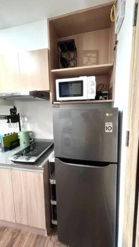 a kitchen with a microwave on top of a refrigerator at Loft Unit One Bedroom with terrace in Davao City