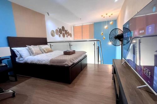 1 dormitorio con 1 cama y TV de pantalla plana en Loft Unit One Bedroom with terrace, en Davao City
