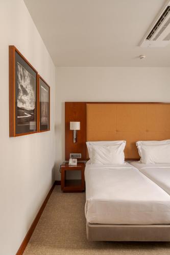 a hotel room with two beds and a table at Hotel Dom Carlos Liberty in Lisbon