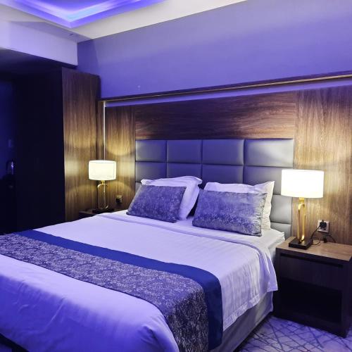 a bedroom with a large bed and two lamps at شقق سوات للشقق المخدومة 2 in Al Khobar