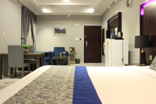 a hotel room with a bed and a desk and a refrigerator at شقق سوات للشقق المخدومة 2 in Al Khobar