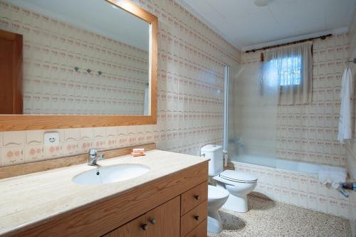 a bathroom with a sink and a toilet and a mirror at Miloca 2 in Playa de Muro