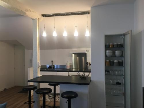 eine Küche mit einer Theke und Hockern in einem Zimmer in der Unterkunft Duplex - Palais de Justice in Toulouse