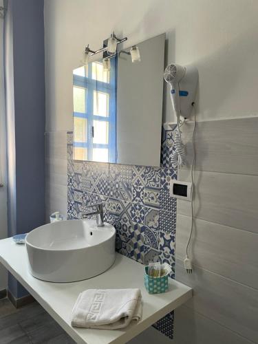 ein Bad mit einem Waschbecken, einem Spiegel und einer Dusche in der Unterkunft A Casa di Giù B&B in Syrakus