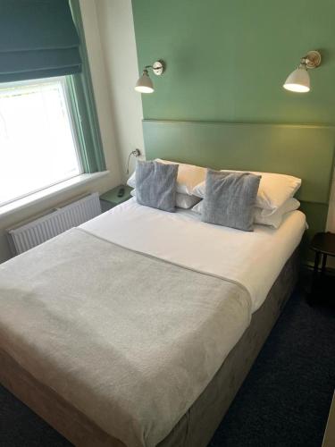 a bedroom with a large white bed with pillows at OYO No 3 in Bath