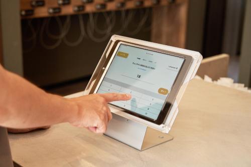a person pointing at an ipod on a table at Hotel STARRIZE in Fukuoka