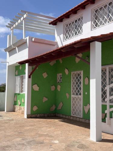una pared verde con corazones pintados en el lateral de una casa en Wave Maze en Vila do Maio