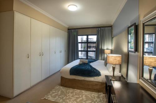 a small bedroom with a bed and a window at Stay at The Point - Exclusive Executives Escape in Durban