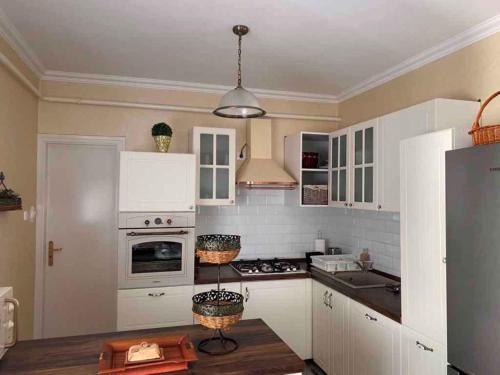 a kitchen with white cabinets and a stove top oven at Holiday home in Gyenesdias - Balaton 40755 in Gyenesdiás