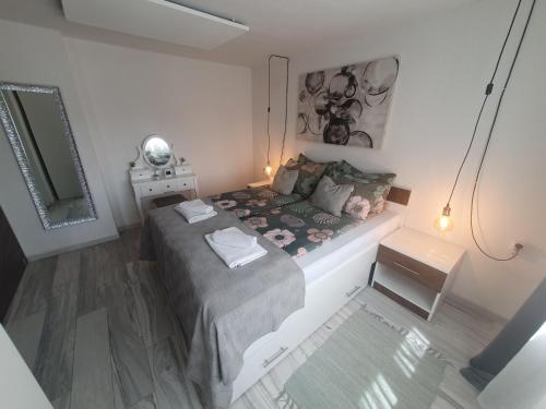 a small bedroom with a bed and a mirror at Apartman Incerum in Požega