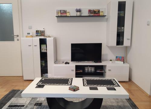 a living room with a white table and a tv at Black and White in Pirot