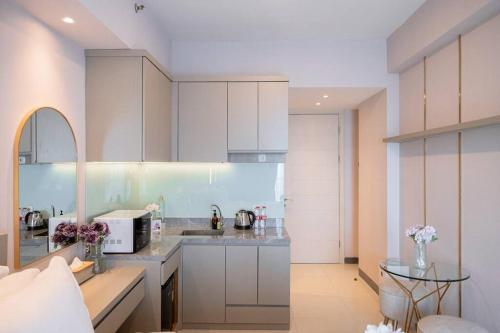 a kitchen with white cabinets and a counter top at ermina at benson pakuwon mall in Surabaya