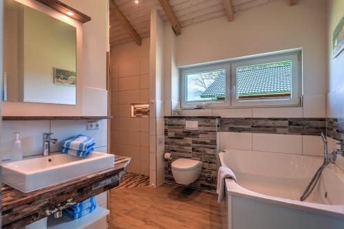 a bathroom with a sink and a tub and a toilet at Ferienhof Brandt in Hedwigenkoog