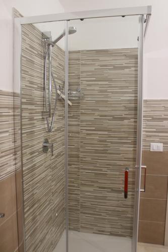 a shower with a glass door in a bathroom at La Casetta di Nonna Angela in Buseto Palizzolo