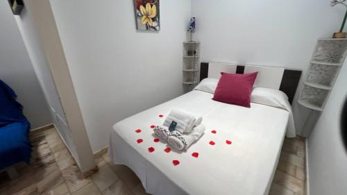 a bedroom with a white bed with red hearts on it at Casita Las Eras en Villa de Nijar con piscina in Níjar