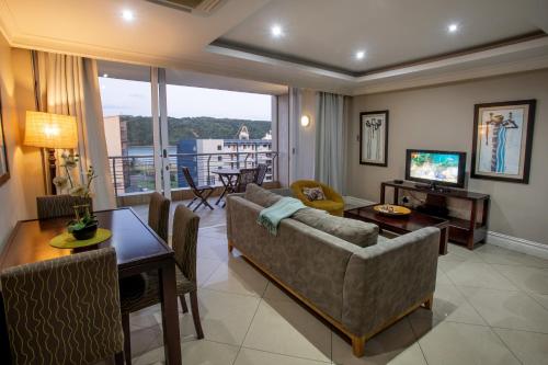 a living room with a couch and a table at Stay at The Point - Seaside Saunter in Durban