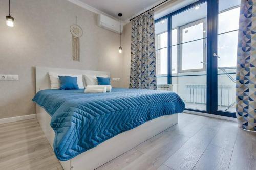 a bedroom with a bed with a blue comforter at Asaapart Ush-Sunkar 164 in Almaty