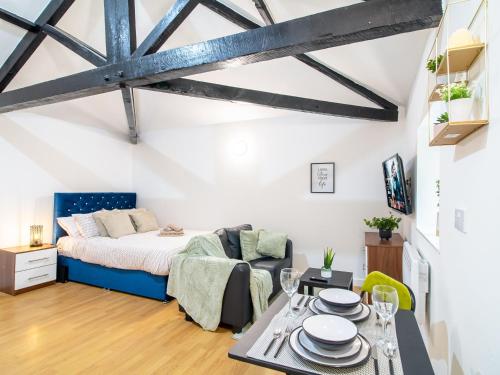 um quarto com uma cama e uma mesa com pratos em Spacious Studio with Parking - 10 Mins to Leeds Centre em Leeds
