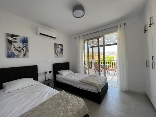 a bedroom with two beds and a balcony at Villa Marina Sea-View Private Pool in Peyia