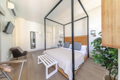 a bedroom with a canopy bed with a chair at nüa cicerone in Seville