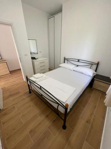 een slaapkamer met een bed en een houten vloer bij AMANTIUS APARTMENTS in Borsh