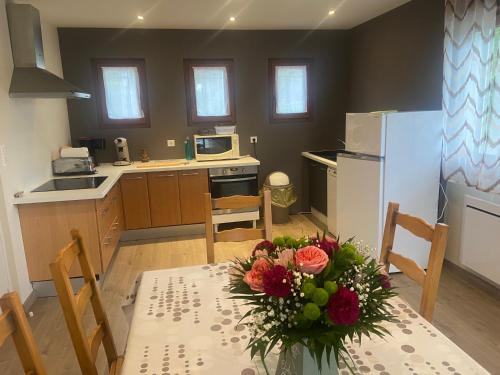 une cuisine avec une table avec un vase de fleurs dessus dans l'établissement Appartement Le Terral, à Salles-Curan